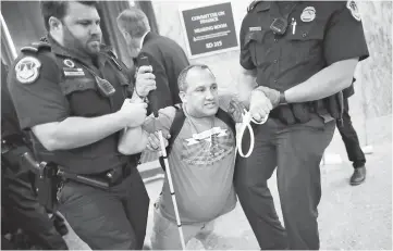  ??  ?? US Capitol Police drag a blind protester out of a Senate Finance Committee hearing about the proposed Graham-Cassidy Healthcare Bill in the Dirksen Senate Office Building on Capitol Hill in Washington, DC. — AFP photo