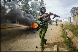  ?? ?? A riot policeman reloads a tear gas grenade launcher during clashes last month with protesters in the Kibera area of Nairobi.