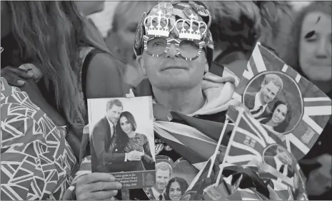  ?? FRANK AUGSTEIN/AP PHOTO ?? A royals’ fan waits Saturday for the wedding ceremony of Prince Harry and Meghan Markle at St. George’s Chapel in Windsor Castle in Windsor, near London, England.