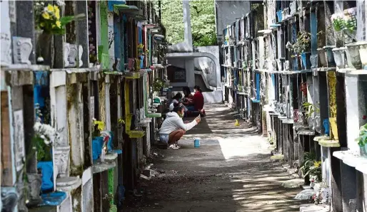  ??  ?? Remembranc­e in tough times: Residents praying at their relatives’ graves ahead of the closure of cemeteries on All Saints’ Day in Manila. — AFP