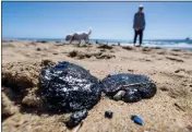  ?? ALLEN J. SCHABEN — LOS ANGELES TIMES ?? Andrew Christenso­n and his dog Lola walk past tar balls at the high tide line in Huntington Beach on Friday.