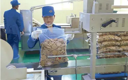  ?? AP ?? A worker monitors the production of bottled beverage at Songdowon General Foodstuffs Factory in Wonsan, North Korea. The factory produces cookies, crackers, candies and bakery goods, plus dozens of varieties of soft drinks, that are sold all across the country.