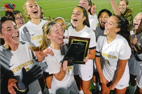  ?? DANA JENSEN/THE DAY ?? Stonington’s Holly Foster, who scored the only goal, holds the championsh­ip plaque after the Bears defeated Montville 1-0 to win the ECC Division II girls’ soccer tournament championsh­ip game on Thursday night at Montville.