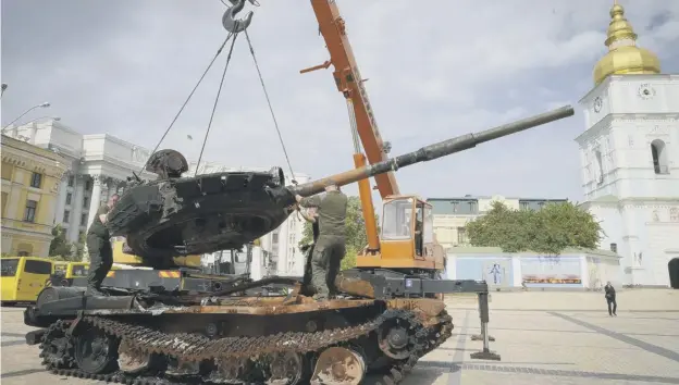  ?? ?? Ukrainian soldiers unload a destroyed Russian tank to install it as a symbol of war in central Kyiv