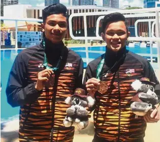  ??  ?? Terrific teens: Hanis Nazirul Jaya Surya and Jellson Jabillin (right) showing off their bronze medals in the men’s 10m platform synchro at the Australian Diving Grand Prix in Gold Coast yesterday.