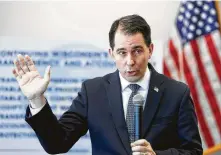  ?? Haley BeMiller / The Post-Crescent via Associated Press ?? Wisconsin Gov. Scott Walker signed a package of GOP-written legislatio­n Friday that restricts early voting and weakens the incoming Democratic governor and attorney general.