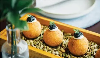  ??  ?? COME FULL CIRCLE
Chien Wei Ho, founder of T’lur Caviar, holding up a toothless sturgeon;
Entier French Dining’s escargot croquettes capped with caviar from T’lur