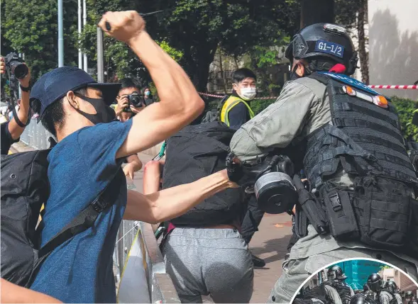  ??  ?? UGLY: A man stabs at a policeman as protests in Hong Kong turned violent. Pictures: AFP, Getty