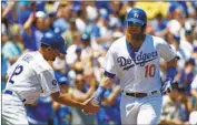  ?? Kent Nishimura Los Angeles Times ?? JUSTIN TURNER is greeted by third base coach Dino Ebel after hitting one of his two home runs.