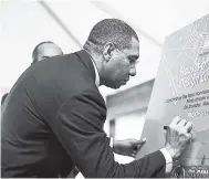  ?? FILE ?? In this May 2018 photo, Prime Minister Andrew Holness signs the unveiled poster for the Houses of Parliament Design Competitio­n.