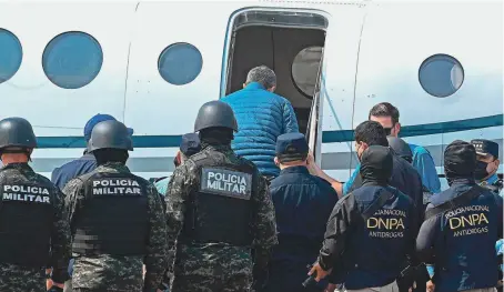  ?? ORLANDO SIERRA/AFP VIA GETTY IMAGES ?? Former Honduras President Juan Orlando Hernández boards a DEA plane during his extraditio­n to the United States.