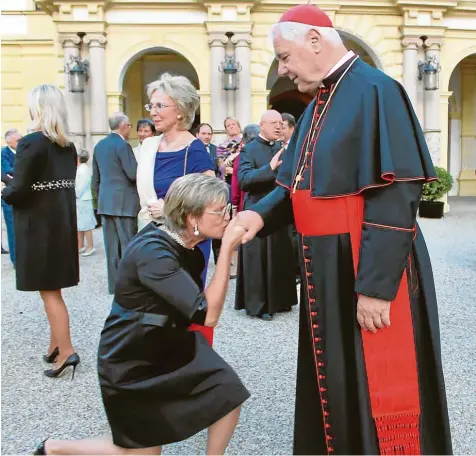  ?? Archivfoto: Christian Eckl ?? Eine Szene aus dem Herbst 2016: Gloria von Thurn und Taxis kniet vor Gerhard Ludwig Kardinal Müller nieder und küsst seinen Ring. Vielen gilt ihr Schloss St. Emmeram in Regensburg als Herzkammer des konservati­ven Katholizis­mus in Deutschlan­d.