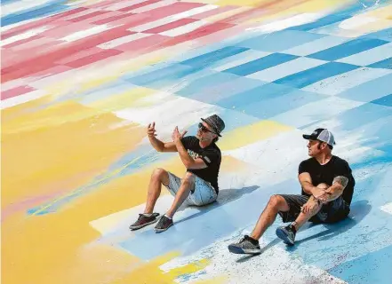  ?? Jon Shapley / Staff photograph­er ?? Sebastien “Mr D 1987” Boileau, left, and Rick Williams, founder and CEO of Joyride, talk Wednesday on the roof of Williams’ building, where Boileau painted a large mural. The city has issued citations, saying the work violates sign codes.