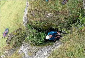  ?? PHOTO: ALAN TENNYSON ?? A Te Papa staff member descends into the cave of fossils and bones near Martinboro­ugh in Wairarapa.