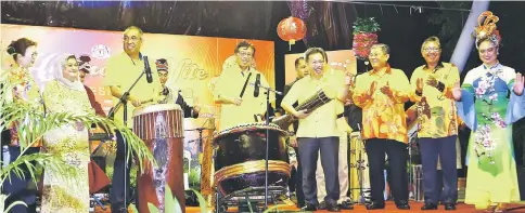  ??  ?? Abang Johari (fifth right), Salleh on his right and Dr Sim on his left, strike the drums to mark the launch of ‘Harmony Nite’ at Kota Sentosa Square. Also seen are Juma’ani (seventh right) and Morshidi (third right). — Photo by Muhammad Rais Sanusi