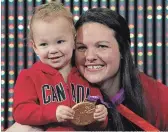  ?? ADRIAN WYLD THE CANADIAN PRESS ?? Canadian weightlift­er Christine Girard poses with her daughter Aliana as she holds the gold medal presented during a ceremony Monday in Ottawa.