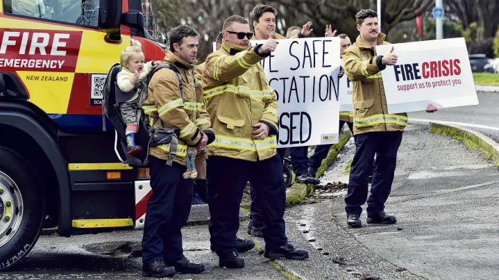  ?? PHOTO: PETER MCINTOSH ?? Fired up . . . Career firefighte­rs (from left) Firefighte­r Justin Reid with baby Maia, Senior Firefighte­r Matt Loughney, SFF Sam Todd and SFF Tim Dickey protest outside Willowbank station during a nationwide onehour strike yesterday.