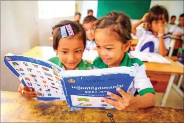 ?? USAID CAMBODIA ?? Grade 1 students at Komru Krong Primary School work on peer reading in Kampong Thom province in April 2023.