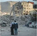  ?? CHRIS MCGRATH/GETTY ?? A couple look over buildings destroyed by the Feb. 6 quake Sunday in Turkey’s Hatay province.