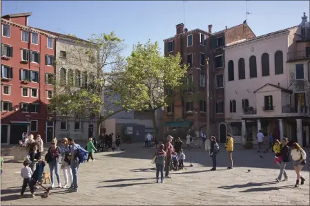  ?? PHOTOS BY GUS POWELL — THE NEW YORK TIMES ?? A square in the historic Jewish Ghetto in Venice, Italy, with the Italian Synagogue in pale pink, at right, on April 21. An $11million project is underway to restore three decaying synagogues in Venice and preserve the city's history of harboring European Jews.