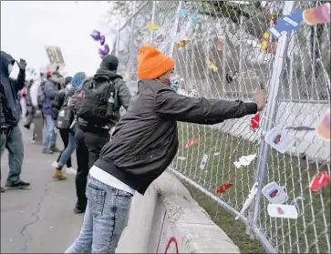  ?? Jason Armond Los Angeles Times ?? PROTESTERS hang car air fresheners on a fence outside the Brooklyn Center, Minn., police station. Daunte Wright, 20, was fatally shot after police pulled him over for having an air freshener on his rearview mirror.