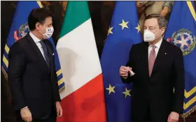  ?? (AP/Andrew Medichini) ?? Outgoing Italian Premier Giuseppe Conte gives the Cabinet-minister bell to successor Mario Draghi on Saturday during a handover ceremony in Rome.