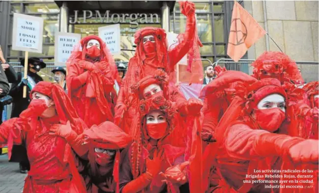  ?? // AFP ?? Los activistas radicales de las Brigadas Rebeldes Rojas, durante una performanc­e ayer en la ciudad industrial escocesa