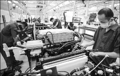  ?? AFP ?? Employees work on a new energy vehicle assembly line at a BYD Auto factory in Huaian in China’s eastern Jiangsu province.