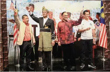  ??  ?? Terima Kasih, Malaysia: Anwar leading the Merdeka celebratio­ns at i- City in Shah Alam. With him is Lim (left).