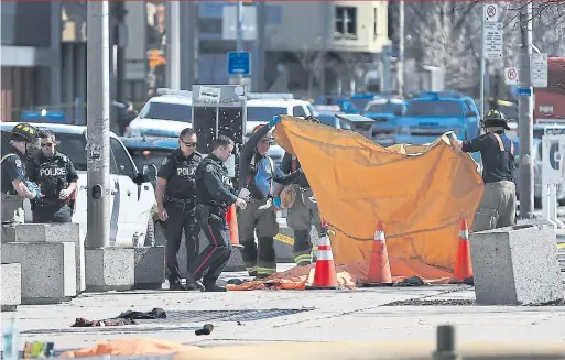  ?? RENÉ JOHNSTON/TORONTO STAR ?? Police and firefighte­rs cover the bodies of victims on a Yonge St. sidewalk, near the entrance to Mel Lastman Square, on Monday afternoon.