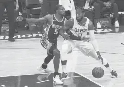  ?? RICH PEDRONCELL­I/AP ?? Clippers forward Paul George, right, drives to the basket against the Kings’ De’Aaron Fox during the first quarter Friday night.