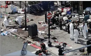  ?? (AP/Elise Amendola) ?? Investigat­ors examine the scene of the second bombing in April 2013 outside the Forum Restaurant on Boylston Street near the finish line of the 2013 Boston Marathon, a day after two blasts killed three and injured more than 260 people.