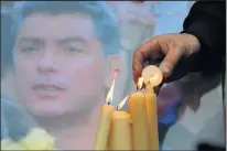  ?? DMITRY LOVETSKY/THE ASSOCIATED PRESS ?? Candles are lit in front of a photo of Boris Nemtsov at a monument to political prisoners in St. Petersburg, Russia, on Saturday. A mourning demonstrat­ion was planned in Moscow.