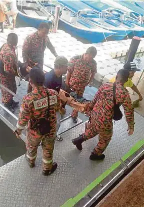  ?? [FOTO IHSAN JBPM] ?? Anggota Bomba dan Penyelamat membawa mangsa yang cedera dalam kejadian jeti runtuh di Pulau Anak Tikus, Langkawi, semalam.