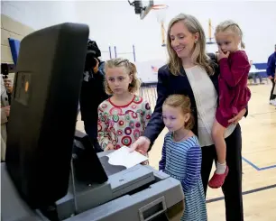  ?? AP ?? Abigail Spanberger, Democratic candidate for Virginia’s Seventh District in the US House of Representa­tives, arrives to vote with her daughters at a polling booth in Virginia. —