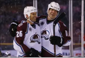  ?? DAVID ZALUBOWSKI — THE ASSOCIATED PRESS ?? Avalanche center Stephane Yelle, left, celebrates his goal with left wing Chris Simon against the Detroit Red Wings in the Stadium Series alumni game at Coors Field in 2016.