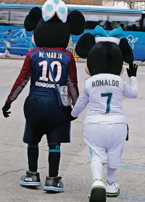  ?? FOTO: AP ?? Zwei Fans haben sich vor dem Hinspiel zwischen Madrid und Paris am 14. Februar als Disney-Figuren, die ein Trikot von Neymar und eins von Cristiano Ronaldo anhaben, verkleidet.