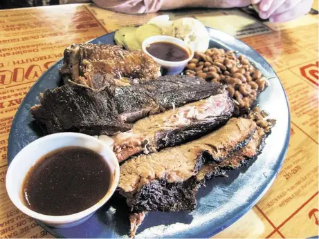  ?? J.C. Reid photos / Houston Chronicle ?? Three-meat plate at the New Zion Missionary Baptist Church Barbecue in Huntsville.