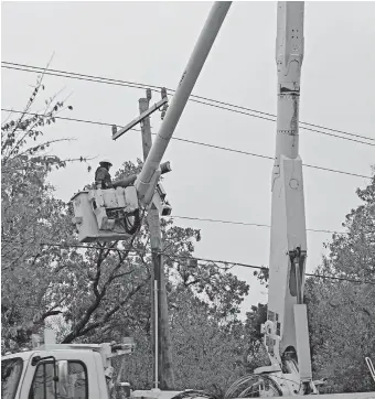  ?? [DOUG HOKE/ THE OKLAHOMAN] ?? Edmond Electric works to restore electric power along South Boulevard on Tuesday.