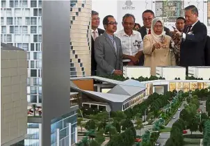  ??  ?? Commanding view: Huan (right) showing a model of the Youth City project to Zuraida as GD Holdings executive chairman Yeat (behind Zuraida) looks on.