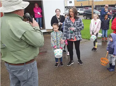  ?? Staff photo by Junius Stone ?? ■ Tim Graham, president of the New Boston Chamber of Commerce, lays out what awaits the egg hunters at this year's Easter egg hunt. Nine thousand eggs awaited them. One egg came with a bicycle as a prize.