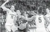 ?? FRANK FRANKLIN II/AP ?? South Carolina’s A’ja Wilson drives past Connecticu­t’s Gabby Williams (15) and Crystal Dangerfiel­d (5).