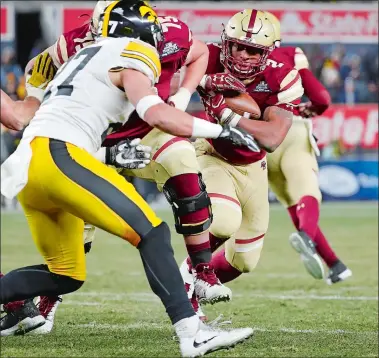  ?? KATHY WILLENS/ AP PHOTO ?? Boston College running back AJ Dillon, right, a freshman from New London, runs through traffic Wednesday night in the Pinstripe Bowl at Yankee Stadium, defended by Iowa strong safety Amani Hooker. Dillon carried 32 times for 157 yards and a touchdown,...