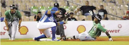  ?? GLAUCO MOQUETE/LISTÍN DIARIO ?? Domingo Leyba, de las Estrellas, se desliza a salvo en la tercera, cuando Juan Kelly, del Licey, trata de ponerlo out.