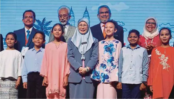  ?? PIC BY SAIRIEN NAFIS ?? Deputy Prime Minister Datuk Seri Dr Wan Azizah Wan Ismail at the launch of the Malaysia Urban Forum at the Kuala Lumpur Convention Centre yesterday. With her are Deputy Housing and Local Government Minister Senator Datuk Raja Kamarul Bahrin Raja Ahmad Baharuddin (back row, second from left), Federal Territorie­s Minister Khalid Samad (back row, second from right) and United NationsHab­itat executive director Datuk Seri Maimunah Mohd Sharif (back row, right).