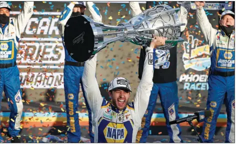  ?? (AP/Ralph Freso) ?? Driver Chase Elliott hoists the NASCAR Cup Series trophy after claiming the championsh­ip with his victory in Sunday’s season-ending race at Phoenix Raceway in Avondale, Ariz. Elliott started at the tail of the field after his car failed pre-race inspection, but he drove to the victory to earn his first series title. More photos available at arkansason­line.com/119nascar.