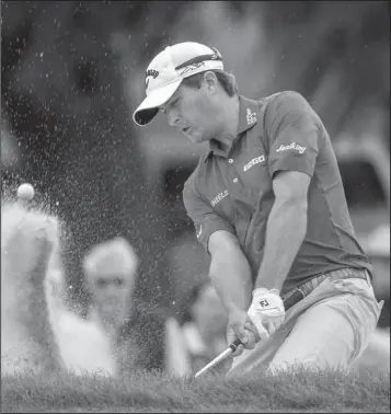  ??  ?? SANDY ISLAND: Kevin Kisner hits out of the bunker on the 15th green on the Seaside Course during the third round at
Classic Saturday at Sea Island Golf Club in St. Simons Island, Ga. Kisner shot 64 Saturday for a two-shot lead.