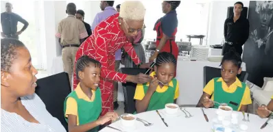  ?? CONTRIBUTE­D ?? Althea Laing assists students of Farm Primary School during a session on etiquette.