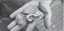  ?? THE ASSOCIATED PRESS ?? Archeologi­st Joe Bagley displays fragments of pottery and a tobacco pipe recovered from the Boston site.