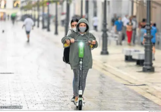  ?? JAVIER ALBIÑANA ?? Imagen de un patinete circulando por la calle Larios, una zona peatonal.